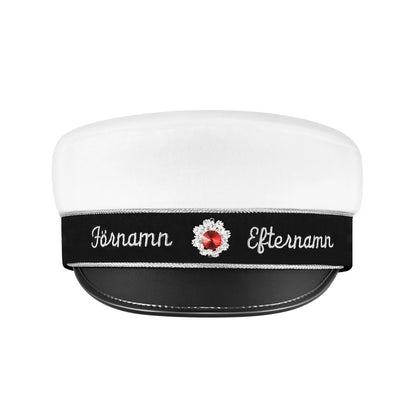 Svart-namnband studentmössa med silverdetaljer och kristall kokard i rödsten framifrån för en klassisk och stilren look.