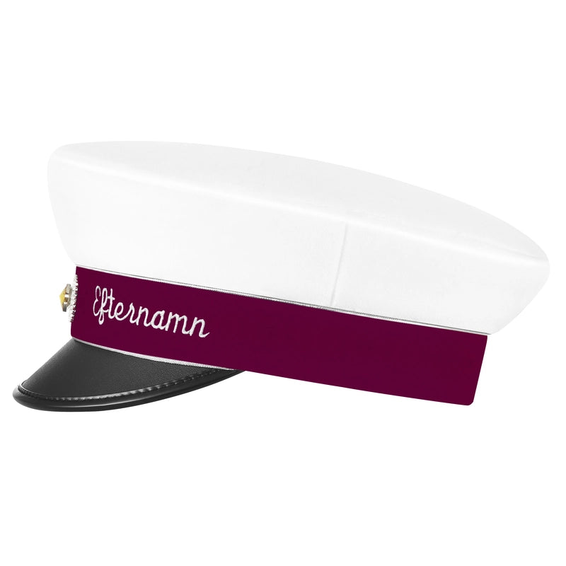 Studentmössa med vinrött namnband, silverkant och silverkokard. Kan anpassas med namn brodyr. Se ifrån sidan. Levereras i en elegant presentförpackning med en silkeslen påse.